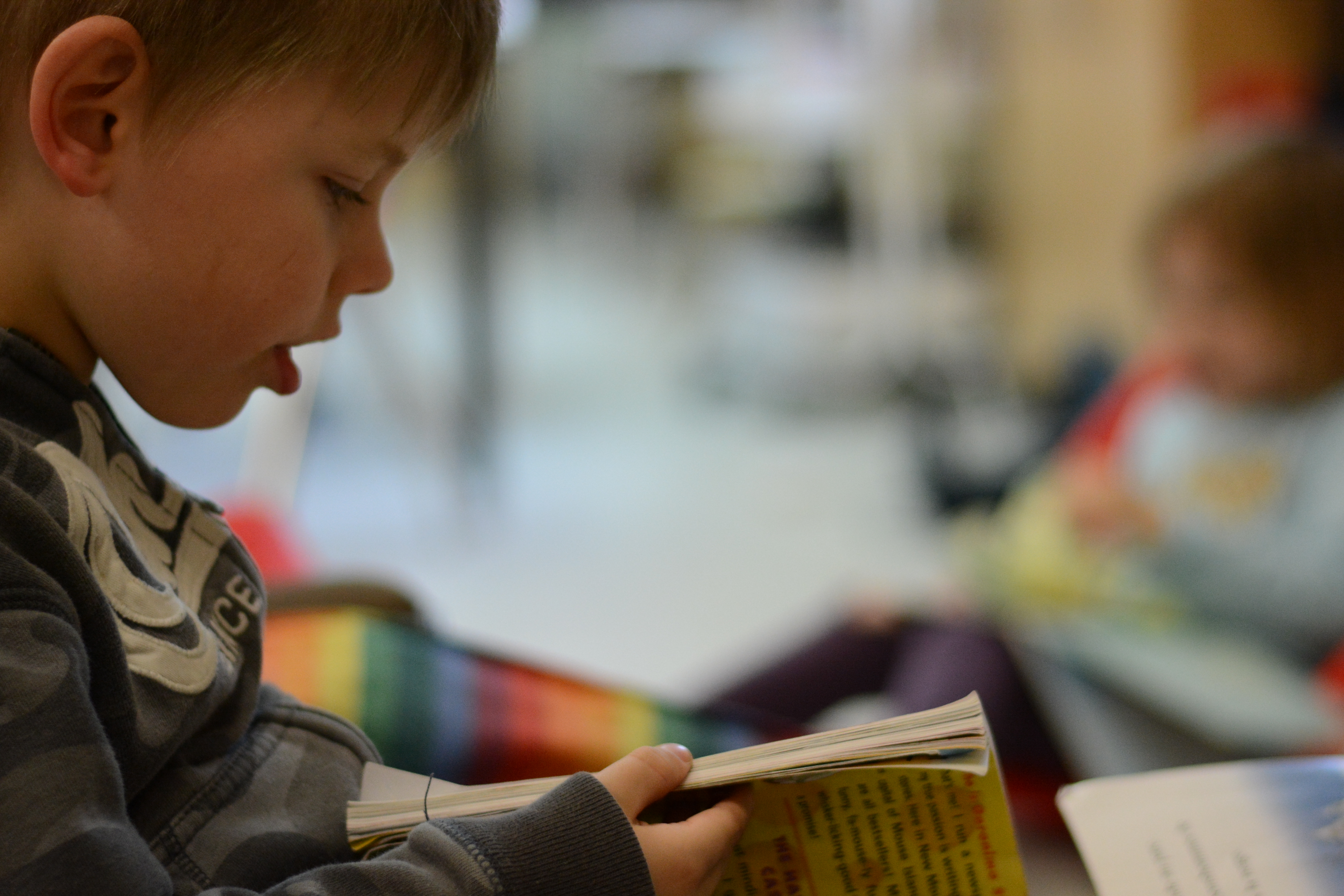A boy flips through a book.
